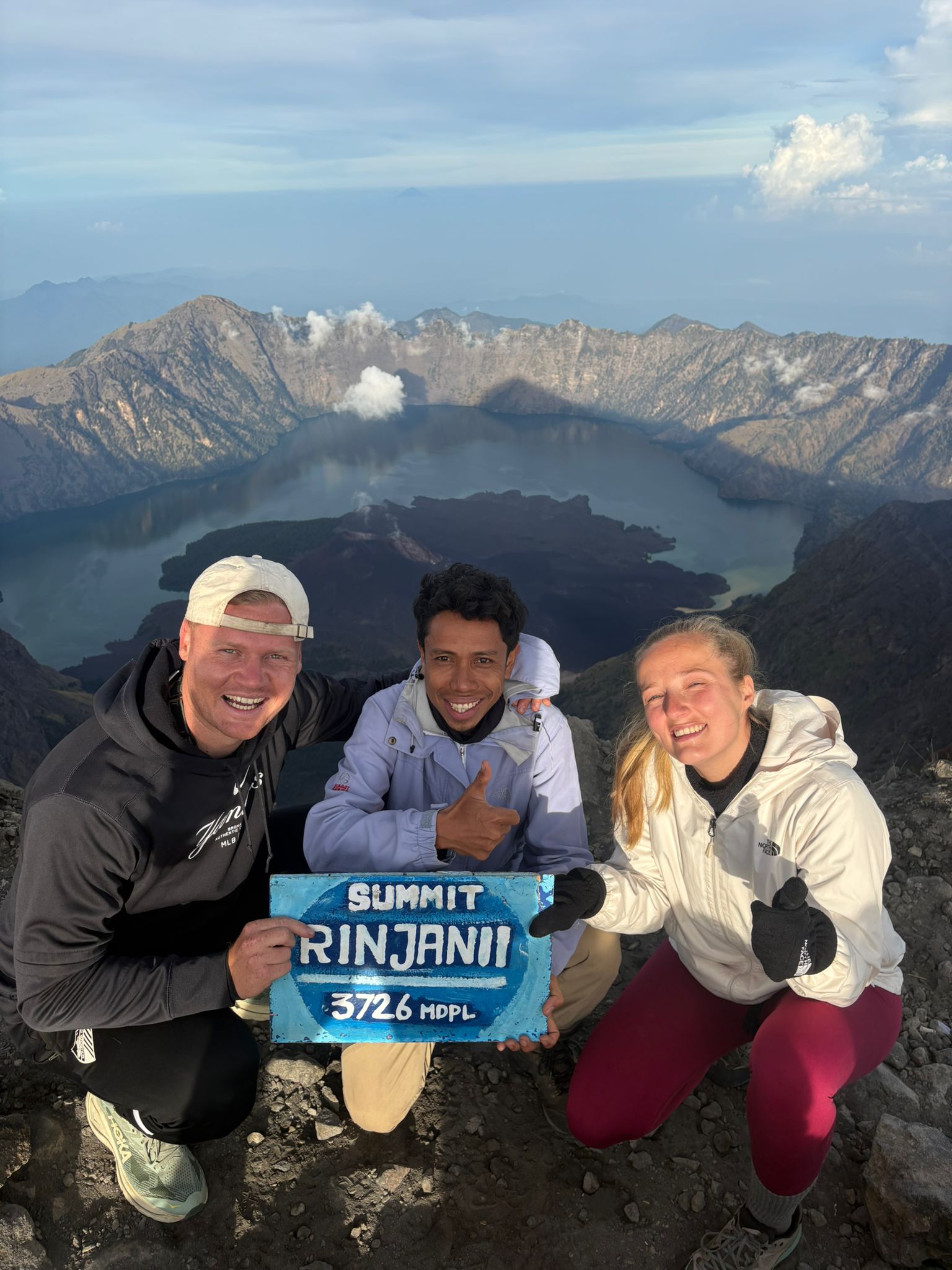 A couple at the Rinjani summit sign with Pak Wil